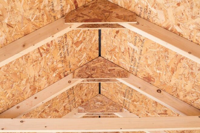 The interior of the roof of an A frame shed showing the wooden braces.